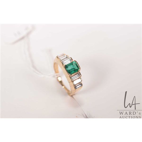 18kt yellow gold and emerald ring. Set with .83ct emerald cut emerald gemstone and six baguette cut 