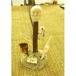 6 1/4 inch tall Ivory, fossilized ivory and bone sculpture with 3 ivory faces, kayak, and baleen on 