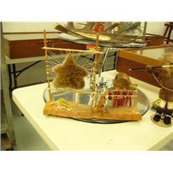 Wood native hunting camp scene with fishing net, salmon and meat drying, spears, bow and arrows, and