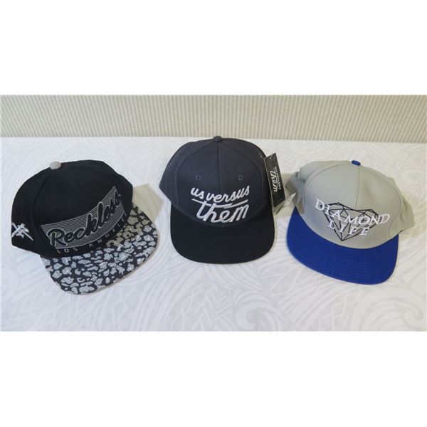 Qty 3 New Ball Caps: Us Versus Them, Diamond Life & Reckless (has security tags on)
