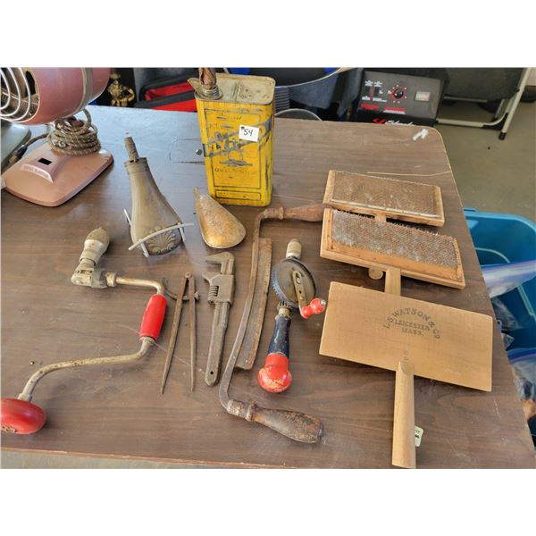 Draw knife, wool carters, 2 hand drills,  old yellow tin, pipe wrench, and 2 brass containers.