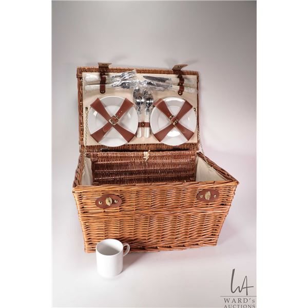 Woven wicker picnic basket fitted for four including sandwich plates, cups and cutlery, appears unus