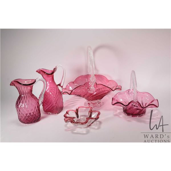 Four pieces of Heritage cranberry glass including handled baskets with applied colourless handles, 8
