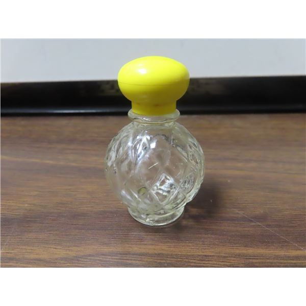 Small clear glass bottle with yellow top.