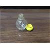 Image 2 : Small clear glass bottle with yellow top.