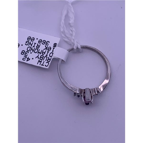 10k white gold ring with ruby centre stone, and 2 melee diamonds; weighs 1.56 grams