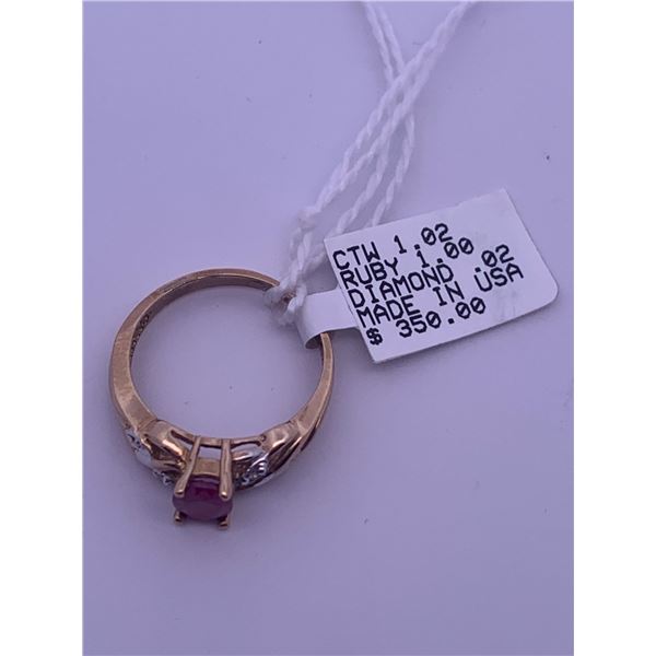 10k yellow gold ring with a ruby centre stone, and 2 melee diamonds; weighs 2.46 grams