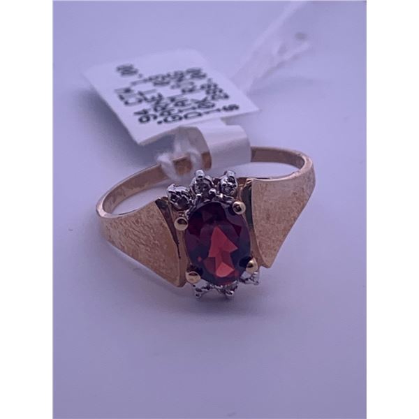 10k yellow gold ring with garnet centre stone, and 6 melee diamonds; weighs 2.17 grams
