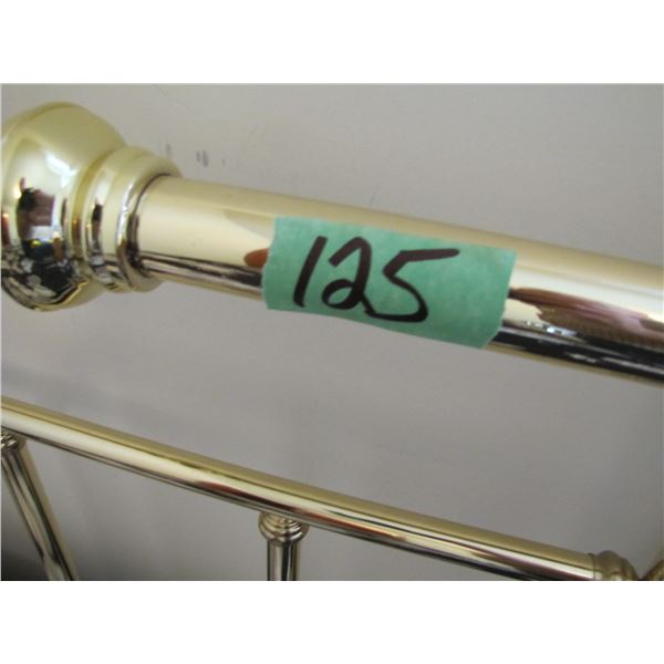 Single bed with brass headboard and box spring and mattress