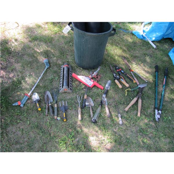 garbage can with lawn and garden tools and items