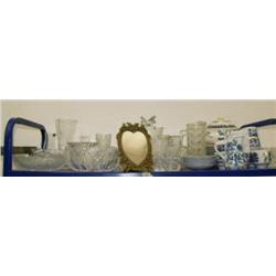 Top shelf of Blue Willow dinner wear, cut and pressed glass vases, crystal bowls, brass picture fram