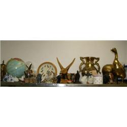 Top shelf consisting of: figures, shells, brass pots, cat, clock, huge brass duck, carved wood eagle