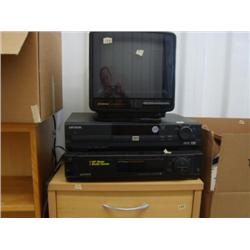 Small bookcase with set of drawers, Sylvania AC/DC remote television, DVD player, Sony VHS recorder,