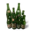 Image 1 : 12 assorted vintage 7-up glass bottles - some with bottling location & 7-up women motif