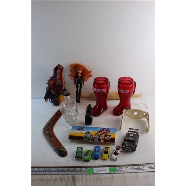 Boomerang, Skull Bottle, (2) I Am Canadian Boot Mugs, Doll, Miniature Racing Cars and Assorted Items