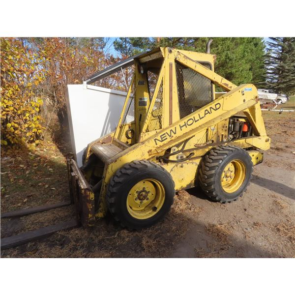 New Holland model L-775 skid steer with forks and bucket
