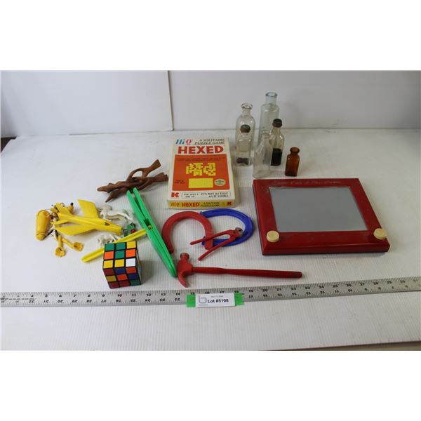 Etch-A-Sketch, Hi-Q Solitaire Puzzle Game, Assorted Toys, Assorted Small Bottles, Rubik's Cube