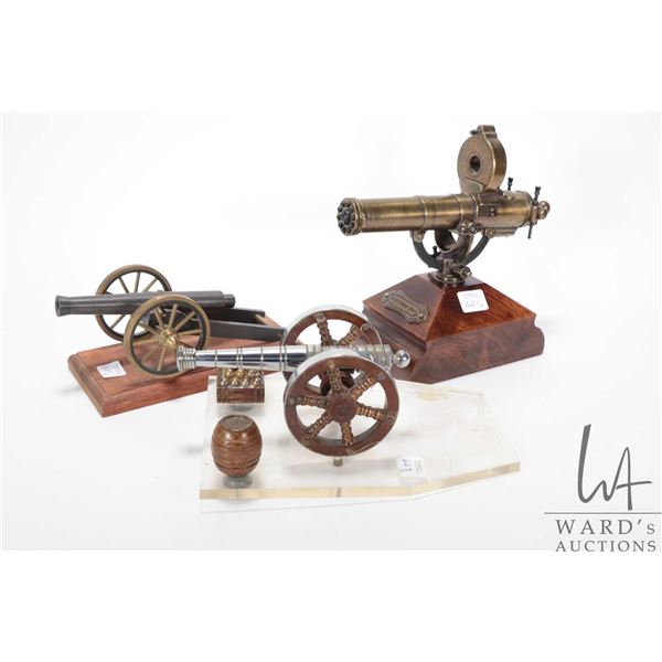 Three collectible cannon displays including a Gaitling gun on wooden plinth marked Hartford Conn. 7 