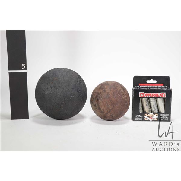 Two cannon balls including 5" diameter rubber and a 4" metal plus a box with four Co2 power canister