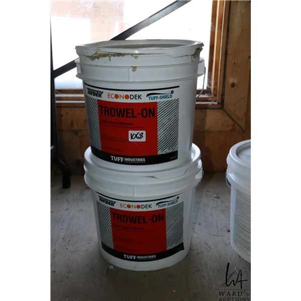 Two 3 gallon buckets of Trowel-on latex vinyl adhesive. One full, one half full.