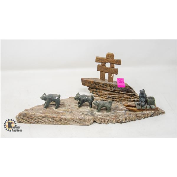 DOG SLED TEAM AND INUKSHUK STONE