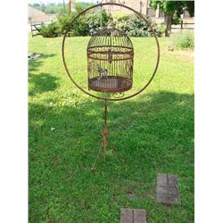 Large metal birdcage on round stand