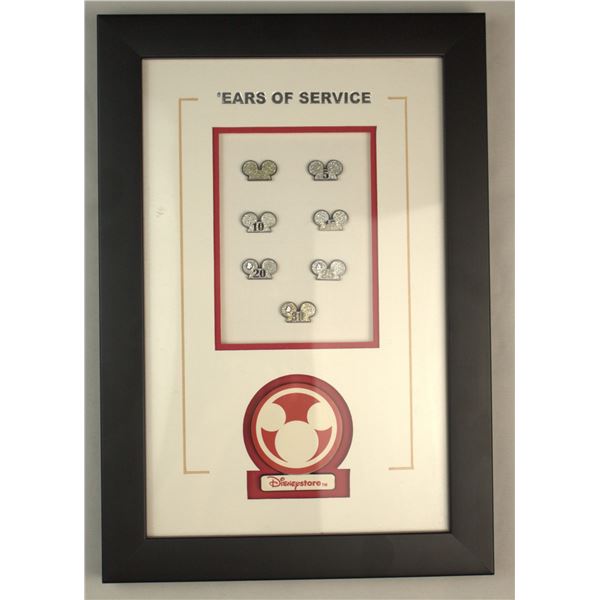 A Disneystore Cast Member 'Ears of Service' Pin Display.