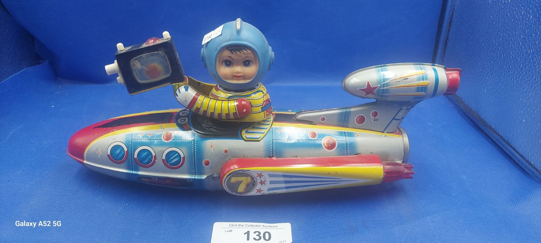 Large 1960s tin toy rocket ship with boy holding camera