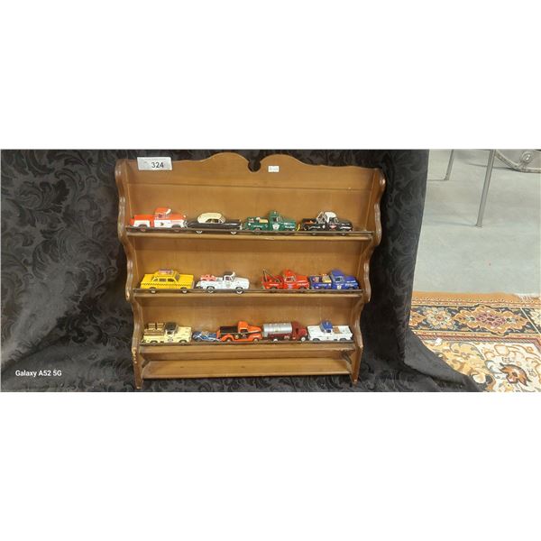 13 die cast trucks on wooden rack, each truck approx 5"