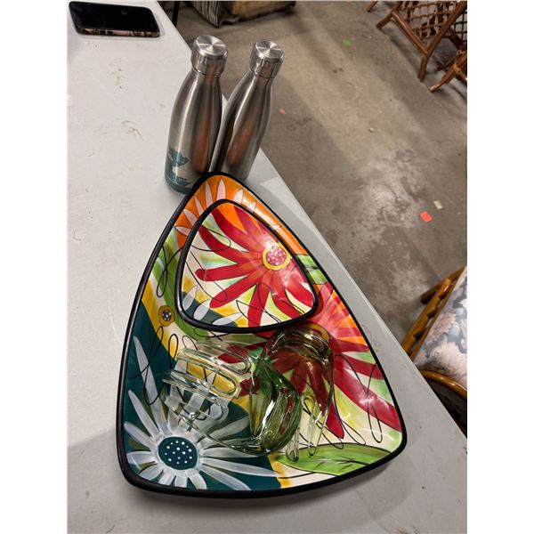 Dishes salad, tongs, and water bottles