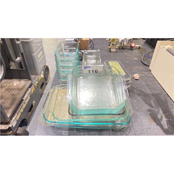 STACK OF ASSORTED SIZE PYREX CLEAR GLASS LABORATORY DISHES WITH SOME LIDS