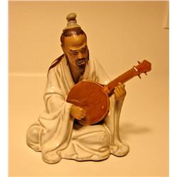 Porcelain Man Playing Instrument