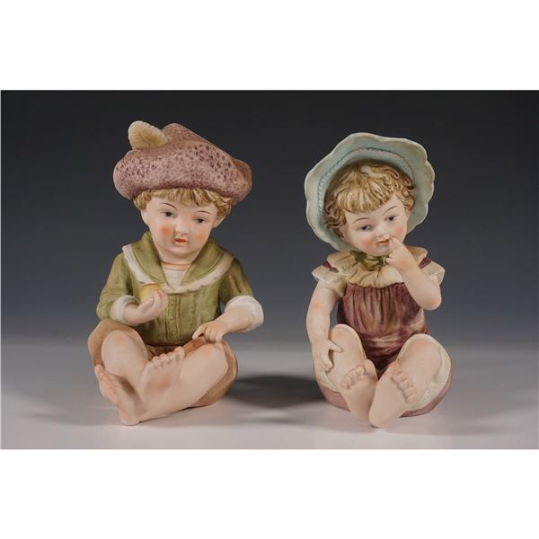 Pair of Seated Boy & Girl Bisque Porcelain Figurines