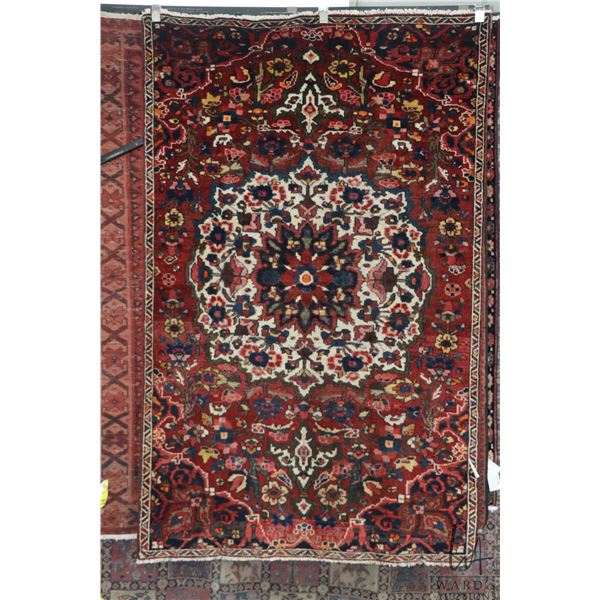 100% handmade Iranian wool carpet "Bakhtyar" with center medallion, red background and overall flora