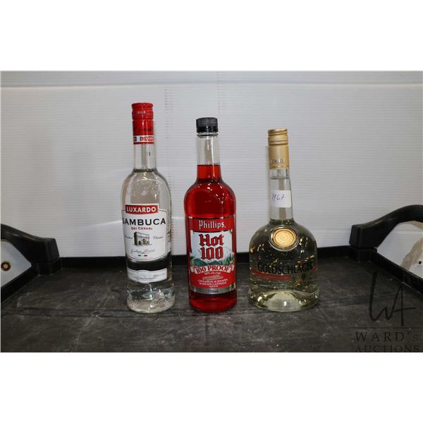 Three assorted bottles of liquor including one Luxardo Sambuca 750ml, one Phillips Hot 100 Cinnamon 