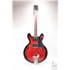 Image 1 : Raven hollow body electric guitar with red burst finish and black pick guard, equipped with Bigsby s