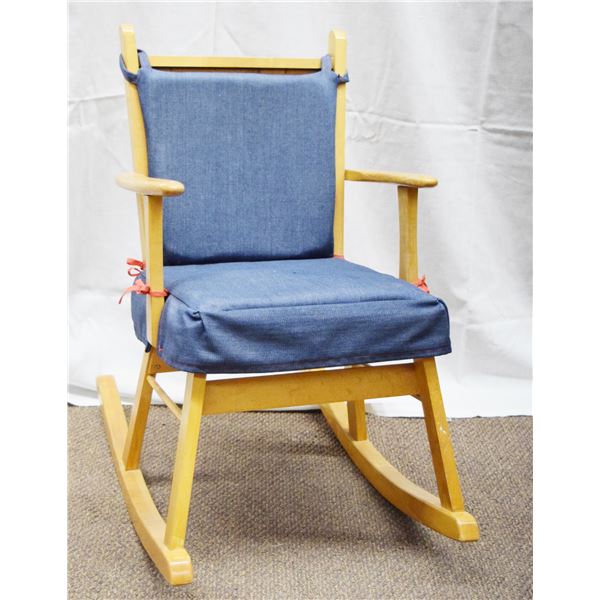 Child's wooden rocker with padded seat and back, solid back with light stain, 26" tall