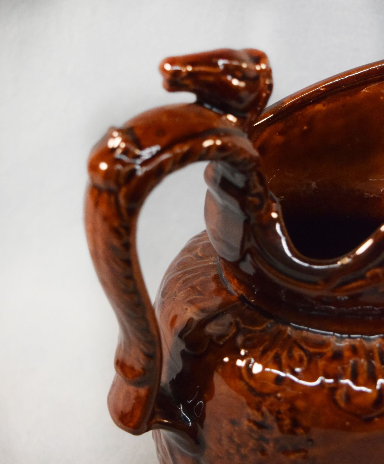 Rockingham Pottery Rockingham Pottery brown glazed pitcher, horse race handle, 8
