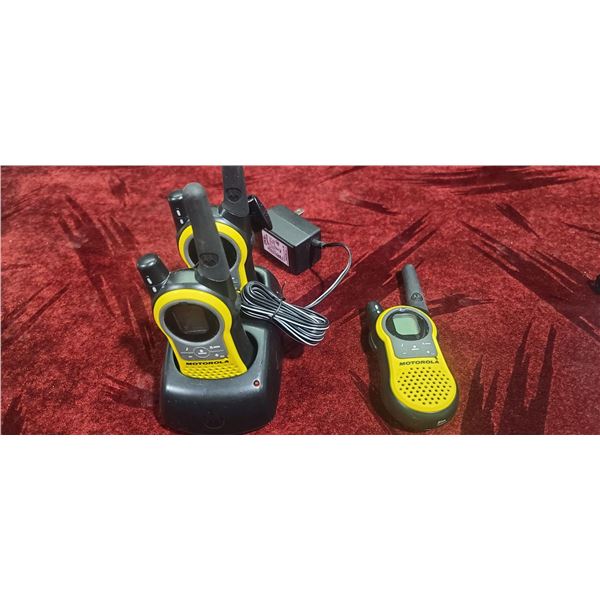 THREE MOTOROLA WALKIE TALKIES AND ONE CHARGING STATION