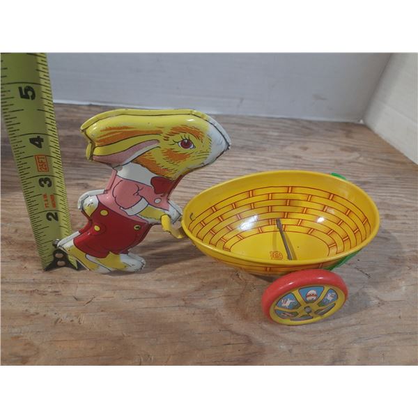 Vintage J chein tin litho easter bunny pushing egg shaped cart.
