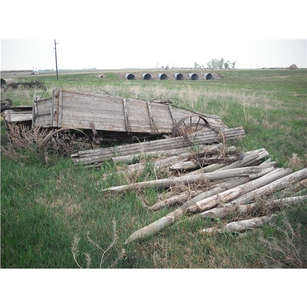 2x wagons with 25" & 28" steel wheels, and assorted poles, barbed wire, boards, etc.