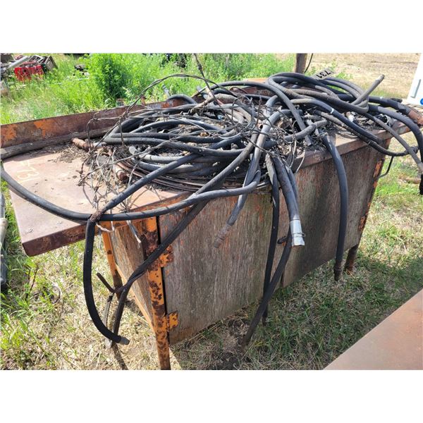 Wooden work bench and hyd hoses.