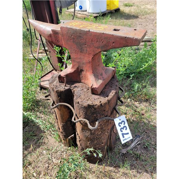 Anvil on wooden stump base. Approx 50-80 pounds.