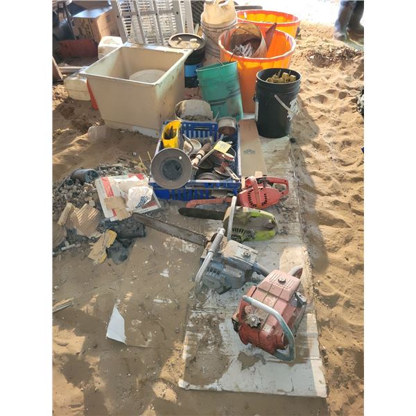 Misc chainsaws and content on floor.