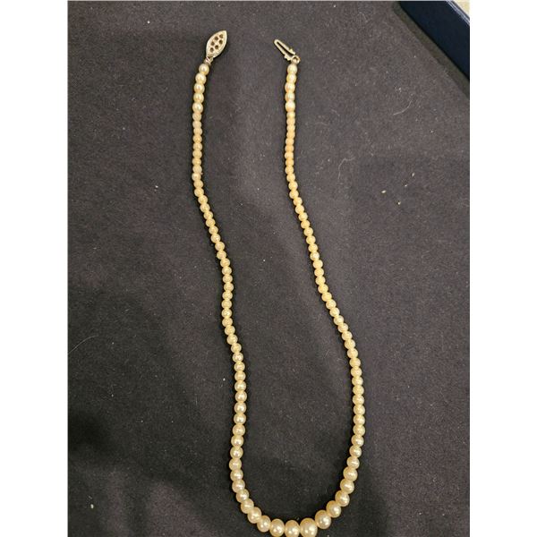 Strand of white, coated (peeling) round beads. 17" long