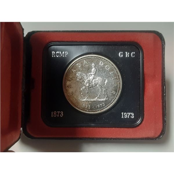 1973 Silver Dollar. Commemorates the founding of the RCMP. Housed in its original RCM clamshell case