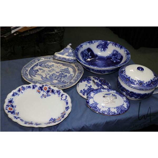 Selection of antique blue and white pottery including wash bowl, lidded comode, platters and three c