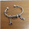 Image 1 : PANDORA bangle bracelet - 925 Silver.  Includes 4 charms and a safety chain charm.  Very nice!