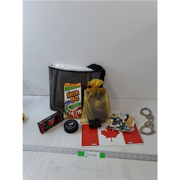 Hockey Puck and Laces, Skip Bo, Hand Cuffs, Lego Pieces, Metal Canada Flag, Book & Bag