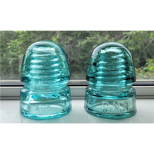 Two CNR turquoise glass insulators, one large print and one small print embossed on glass.